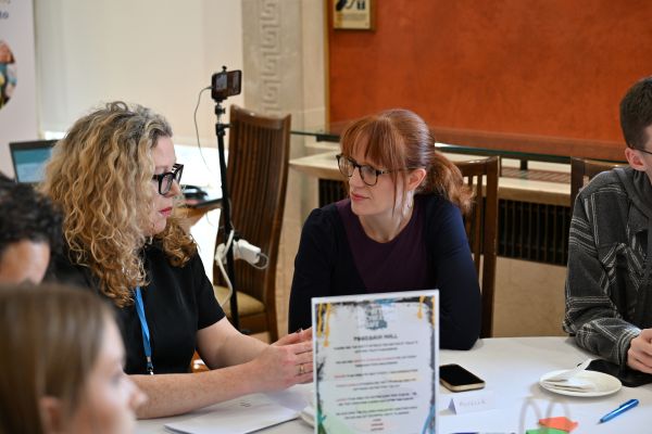 This photo shows CiNI CEO Natalie Whelehan and Michelle Guy MLA. They are sitting at a table involved in a group discussion as part of the Cyber Cafe event