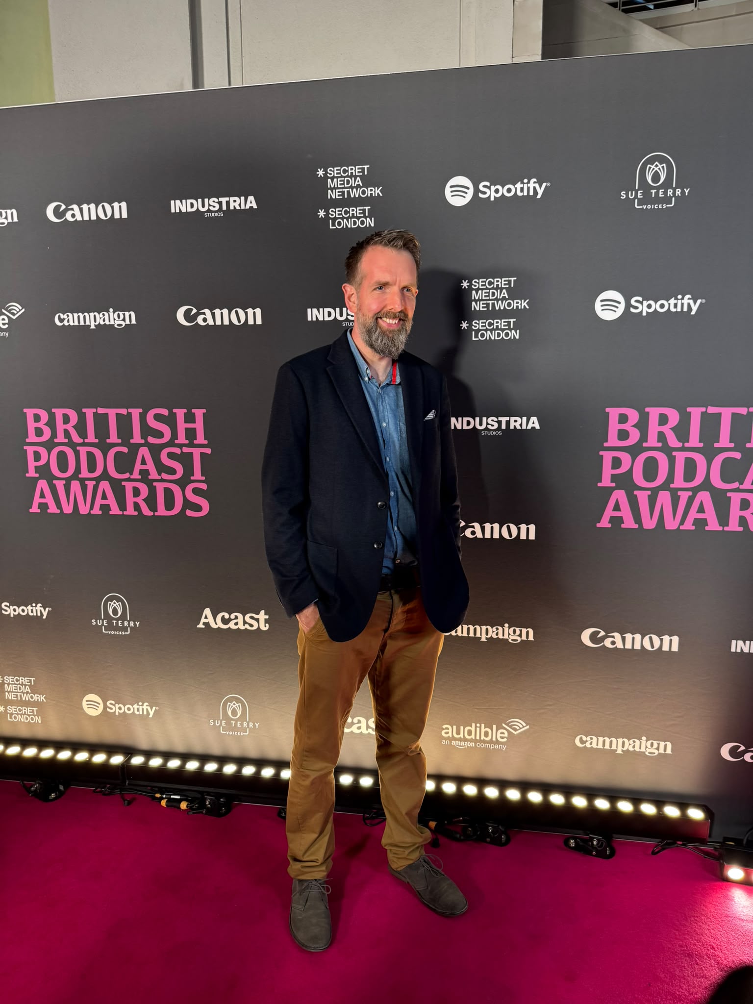 Roger Gowdy pictured on the red carpet at the entrance of the British Podcast Awards.