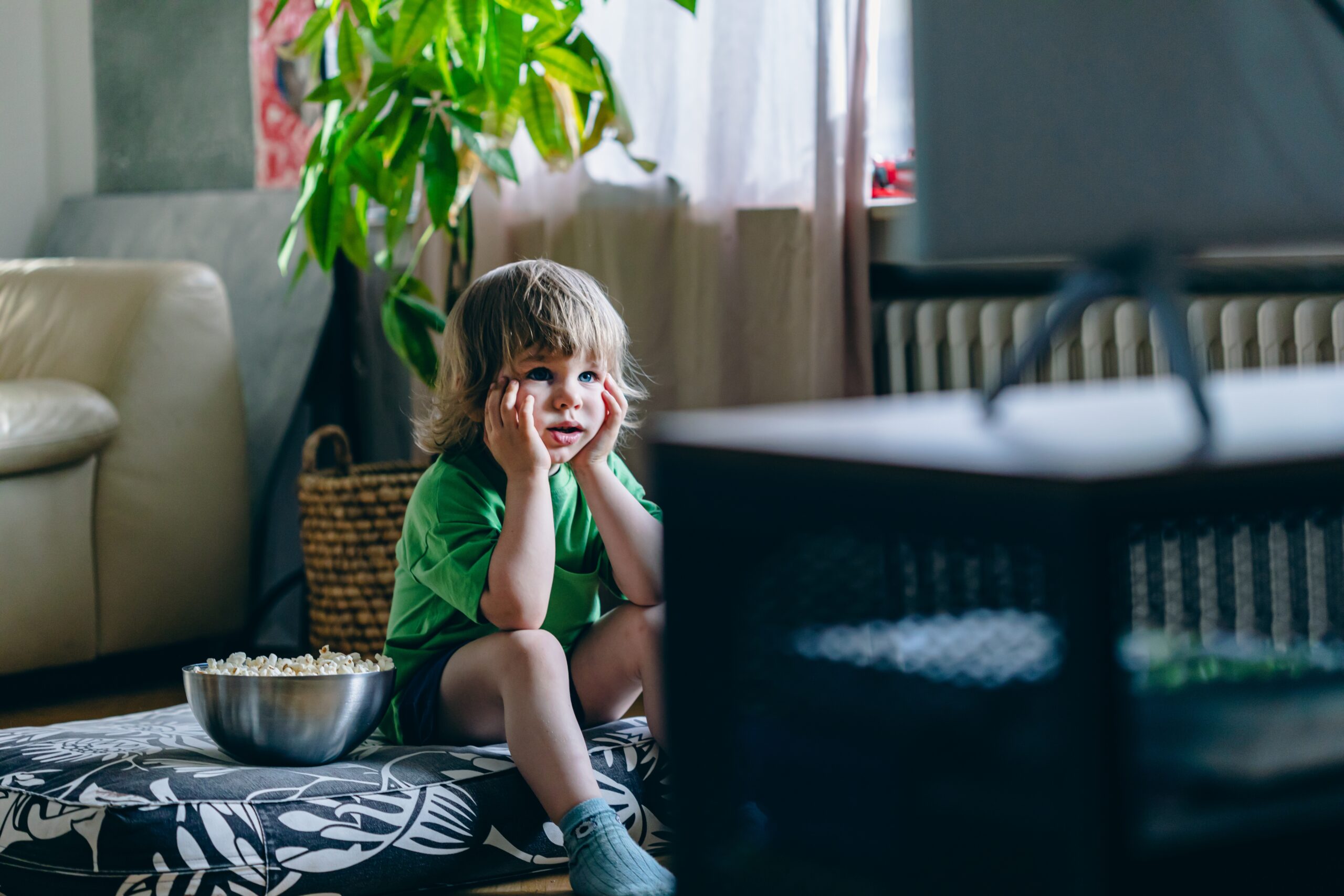 Young boy sitting on floor watching TV